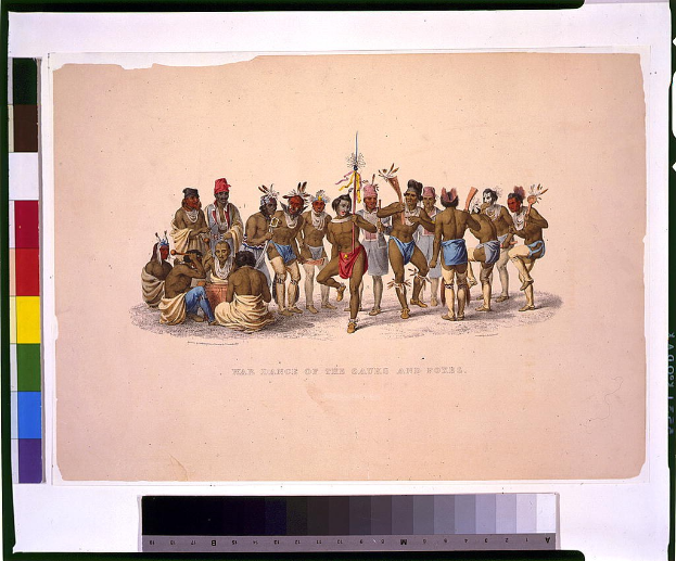 Gruppe von Männern in traditioneller indianischer Kleidung führt einen Kriegstanz auf einem farbenfroh bedruckten Papier mit sichtbarem Text aus.