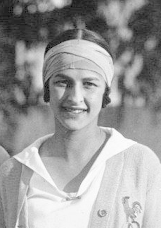 Schwarz-weißes Foto einer lachenden Frau mit Turban, die angeblich die erste Frau war, die ein Tennis-Turnier gewann, mit einem unscharfen Hintergrund.