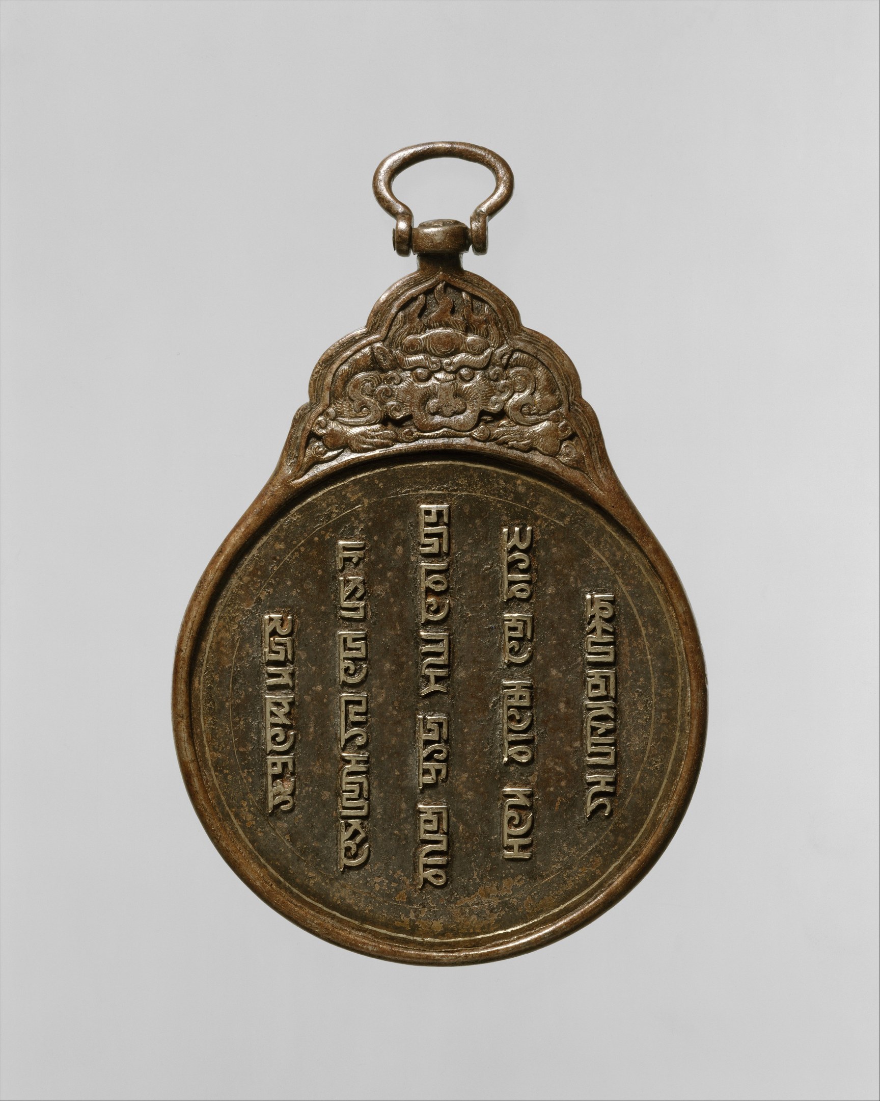 Bronzemedaille mit chinesischer Schrift auf weißem Hintergrund.