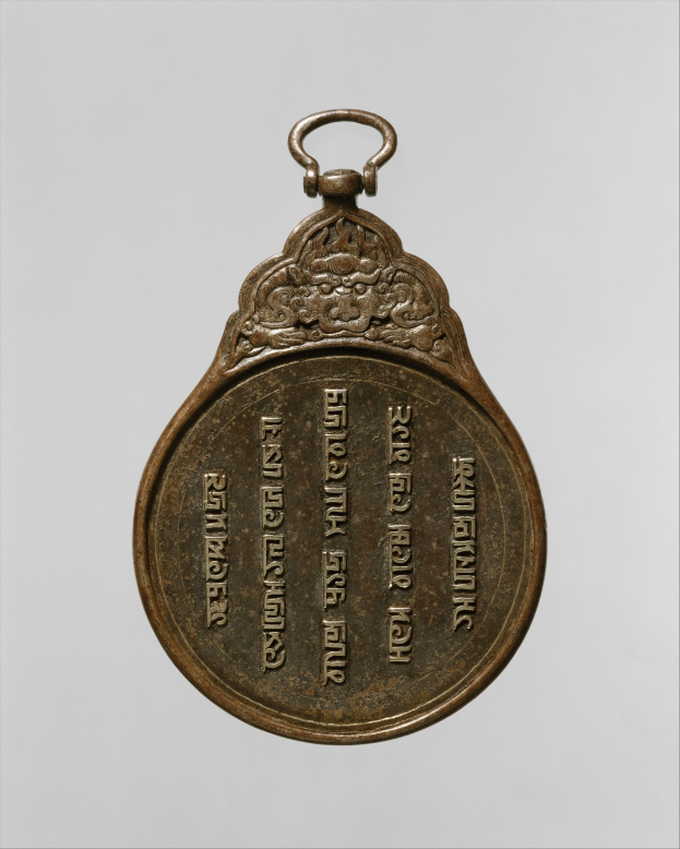 Bronzemedaille mit chinesischer Schrift auf weißem Hintergrund.