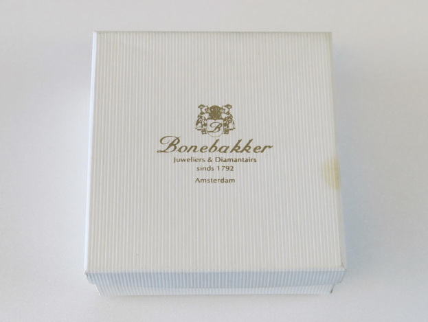 Weißer Karton mit goldenem 'Bonebakker Jewelers & Diamonds'-Logo auf einer weißen Oberfläche.