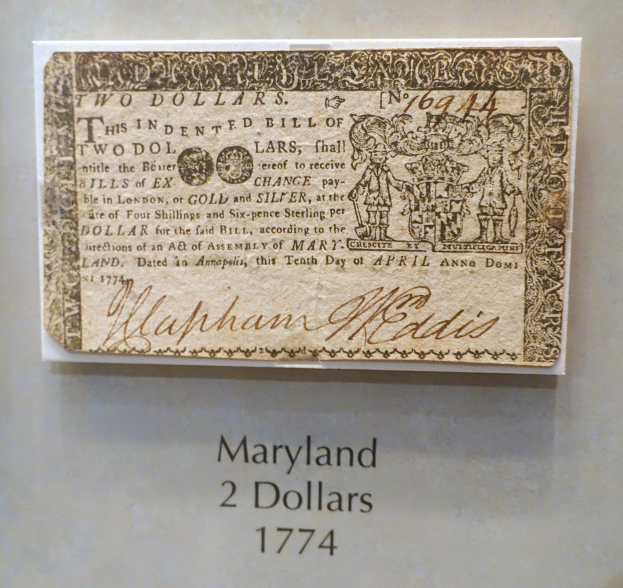 Eine Maryland-Zweidollarnote von 1774 in einer Glasvitrine mit lesbarem Text.