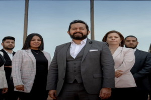 Gruppe von Menschen vor einem Gebäude mit Glaswand und Himmel im Hintergrund, identifiziert als Besetzung von 'The Real Housewives of Beverly Hills'.