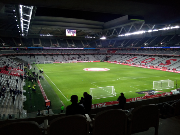 Großes Stadion voller Zuschauer bei einem Fußballspiel im Estadio Santiago Bernabeu in Madrid, Spanien, unter Stadionbeleuchtung mit einem Bildschirm oben sichtbar.