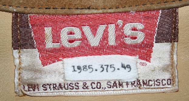 Ein leuchtend rotes Levi's-Label mit weißer Schrift auf der Rückseite einer klassischen Fünf-Taschen-Jeans-Design, mit Reißverschluss und Knopfverschluss.