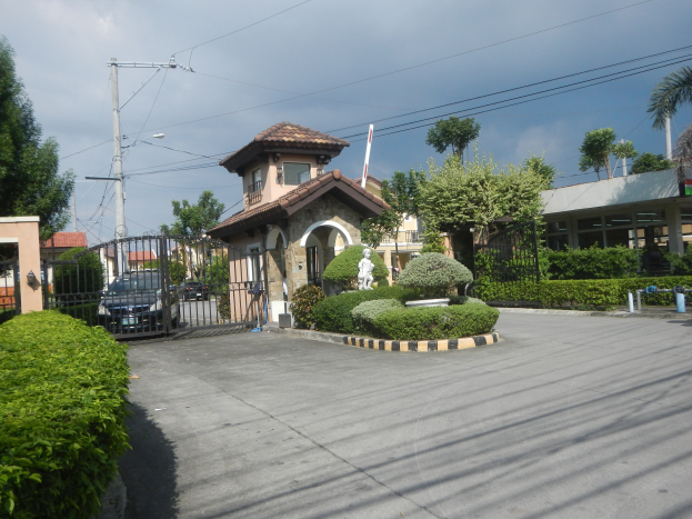 Luftaufnahme eines zu verkaufenden Grundstücks in Cebu City, Manila Metropolitan Area, mit Gebäuden, Fahrzeugen, Statuen, Grünflächen, Strommasten und einer bewölkten Himmel