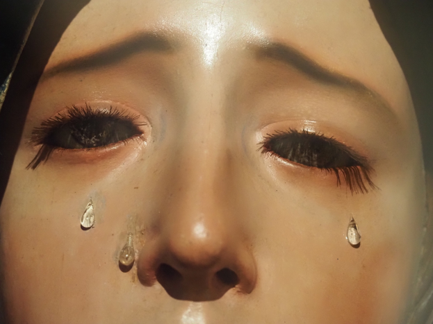 Eine Frau mit Tränen auf den Wangen, deren Gesichtsausdruck Trauer und Verzweiflung ausdrückt.