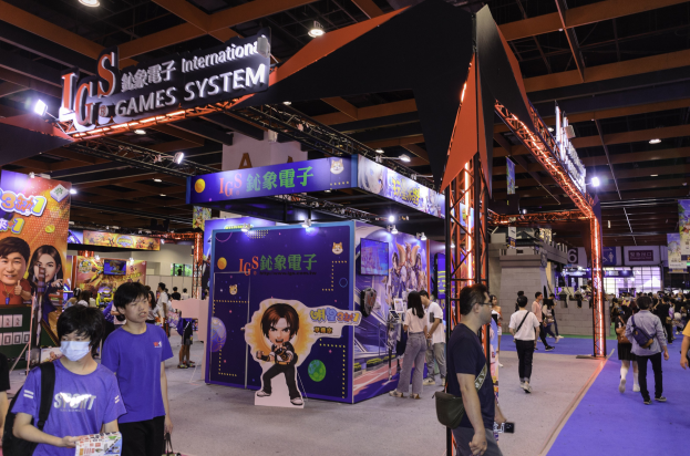 Eine Gruppe von Menschen, die durch einen Konferenzsaal auf einer Gaming-Messe in China gehen, einige tragen Taschen und halten Gegenstände, mit Displaytafeln, Deckenleuchten und einem Teppichboden.