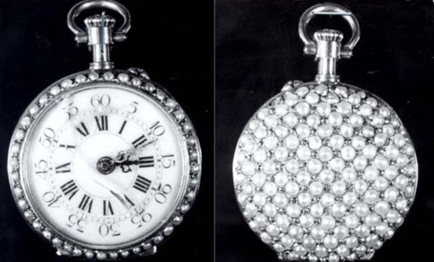 A silver pocket watch with diamonds embedded in it, featuring a round face with Roman numerals, set against a black background.