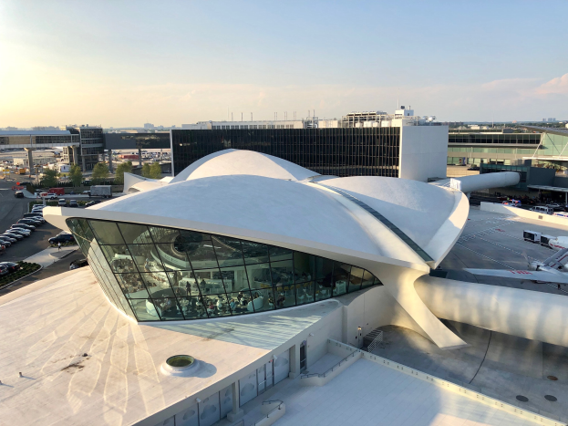 Luftaufnahme des neuen Terminalgebäudes am Los Angeles International Airport mit umgebenen Infrastruktur und Fahrzeugen bei bewölktem Himmel.