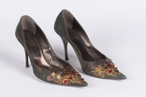 Grüne High Heels mit goldenen und roten Kristallen, spitzer Zeh und Stiletto-Absatz auf einem weißen Hintergrund.