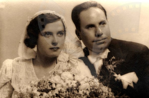 Ein Schwarz-Weiß-Foto eines Mannes und einer Frau an ihrem Hochzeitstag, die Frau in einem weißen Kleid und mit einem Strauß Blumen in der Hand.