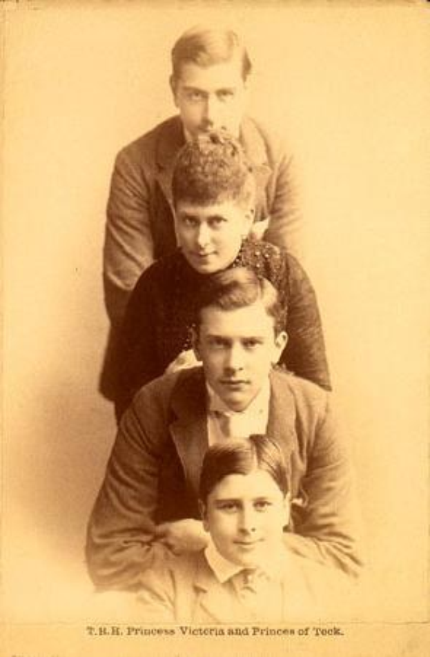 Schwarzes und weißes Foto einer Familie, die zusammen posiert, mit Text unten, der "T.H. Prinzessin Victoria und Prinzen von Rock" lautet.