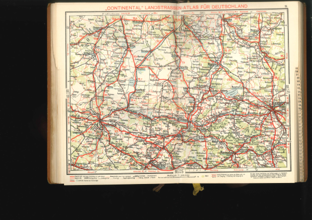 Offenes Buch mit einem detaillierten Straßenkarten-Plan von Deutschland auf schwarzem Hintergrund.